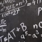 close up of complicated equations written on a blackboard